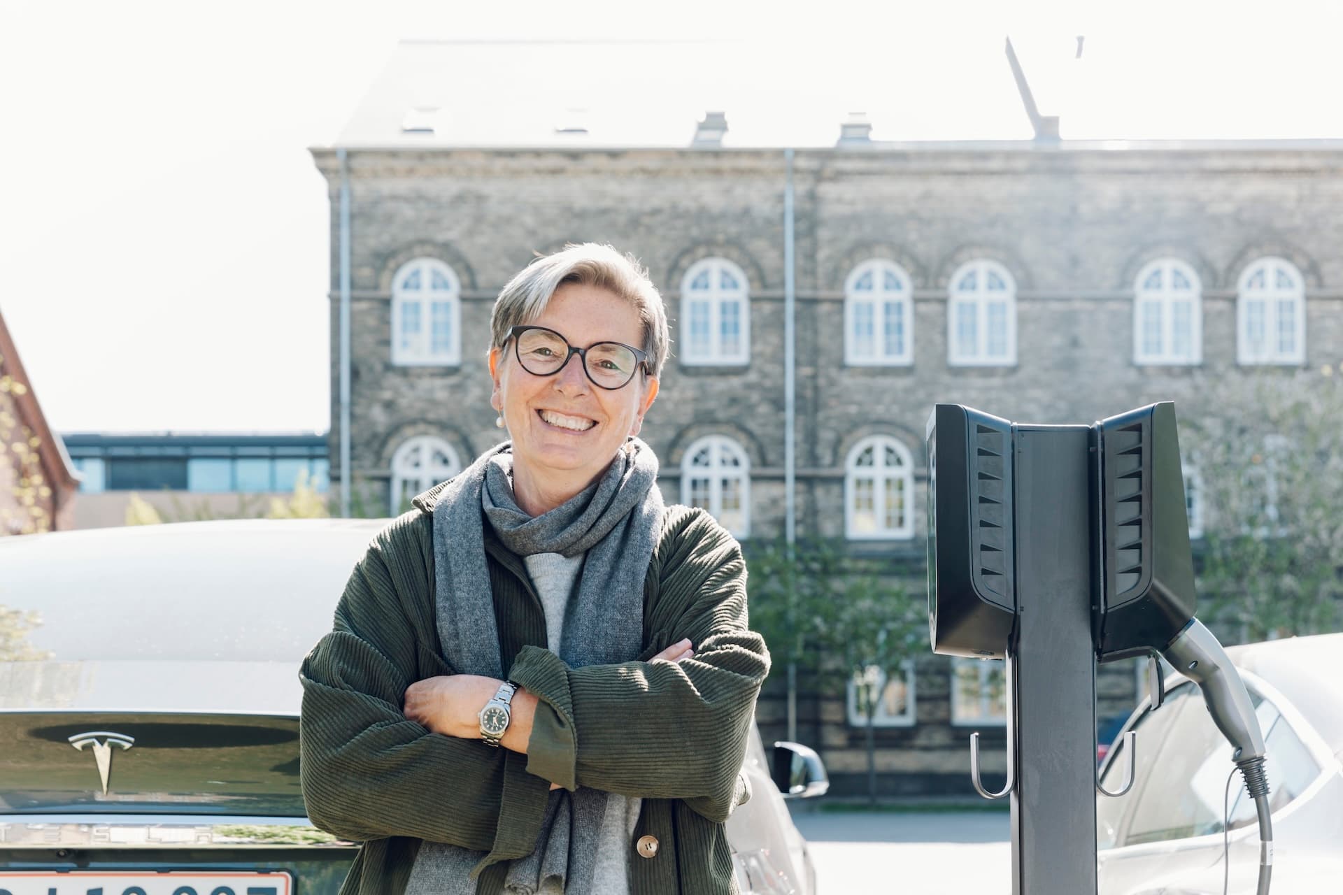 Kirsten Larsen ved en Easee Ready og en Easee elbillader, utenfor sitt borettslag